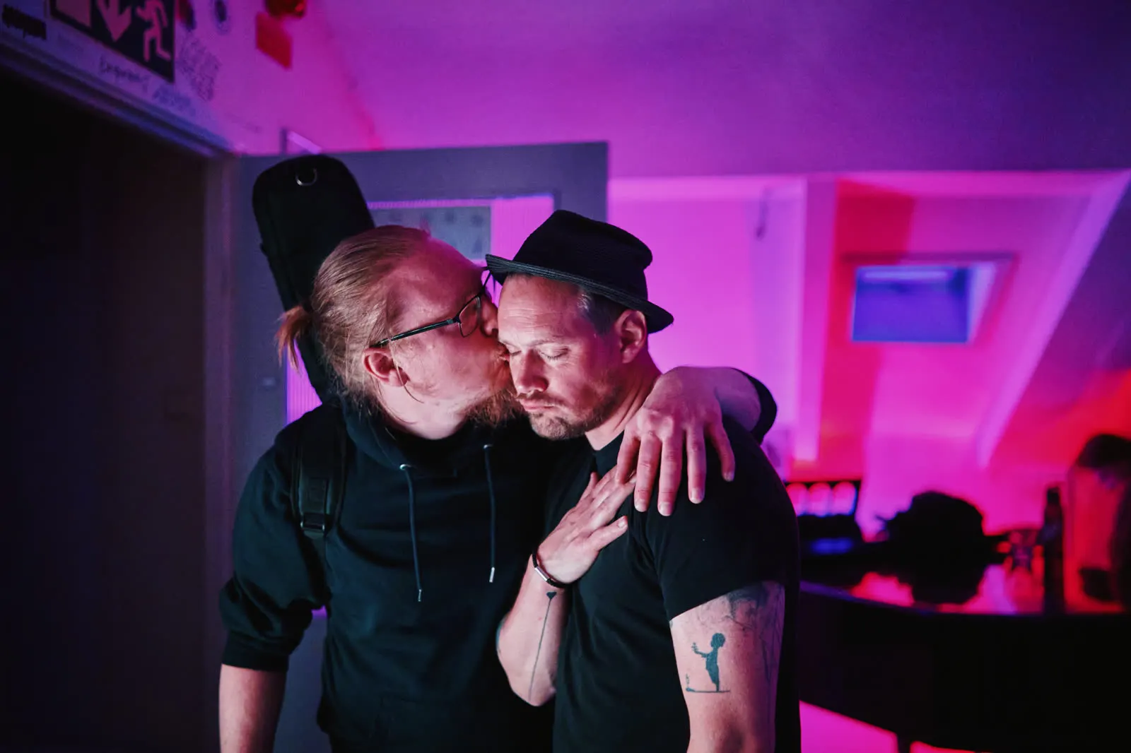 Två bandmedlemmar i rosa ljus